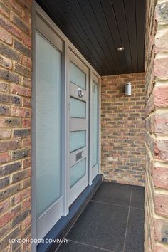 the front door of a brick building with glass panels on it's windows and doors