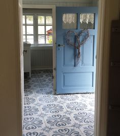 a blue door is open in a room with white walls and tile flooring that looks like it has been painted