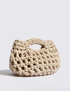 a woven bag sitting on top of a white surface