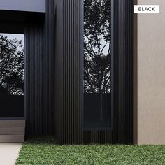 a black building with grass in front of it and trees reflected in the glass windows