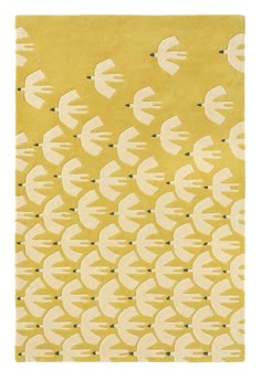 a yellow rug with white fish on it