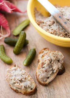 there are some breads and pickles on the table