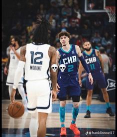 two basketball players are standing on the court and one is holding a ball in his hand