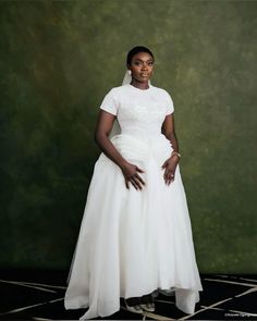 a woman in a white dress posing for a photo with her hands on her hips