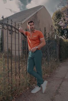 a man leaning against a fence with his hand on the gate