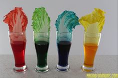 four glasses with different colored liquids in them