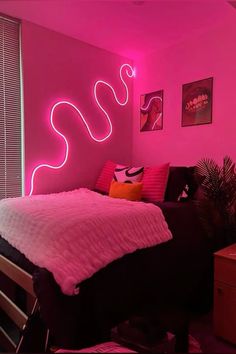 a bedroom with pink walls and neon lights on the wall, along with a bed