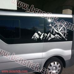 a van parked in a parking lot with mountains and compass decals on the side