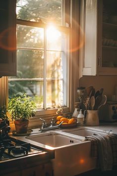 the sun shines brightly through an open window over a kitchen sink with utensils on it