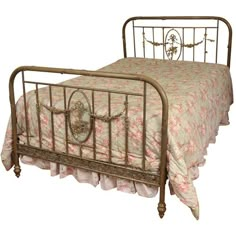 an antique iron bed with pink bedspread