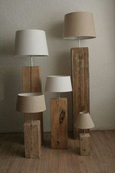 three lamps sitting next to each other on top of a wooden floor near a wall