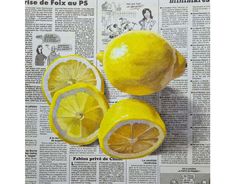 three lemons cut in half sitting on top of a newspaper