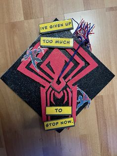 a graduation cap that has been made to look like a spiderman with words on it