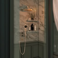 a bathroom with marble walls and shelving on the wall next to a shower head