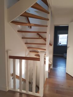 an empty room with wooden stairs and white walls