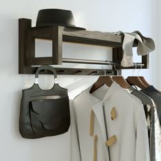 there is a coat rack with clothes hanging on it and a hat hanging from the wall