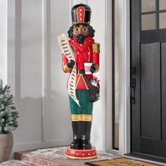 a large nutcracker statue sitting on top of a brick step next to a door