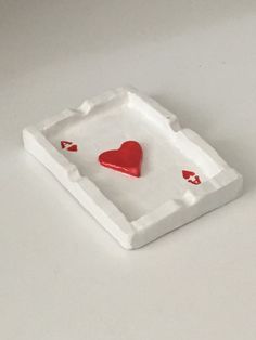 a red heart in a white tray on a table