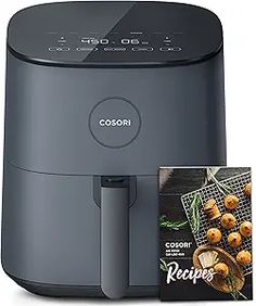 the cosori air fryer is on display with its box and cookbook