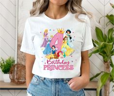 a woman wearing a birthday shirt with princesses on it