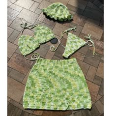 a crocheted green skirt and matching hat on the floor with other items to sew