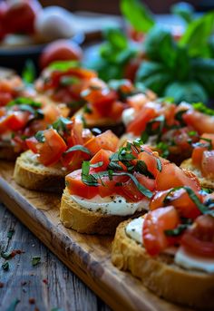 bread topped with tomatoes and cream cheese on a cutting board