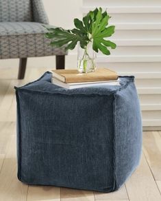 a small blue ottoman with a plant on top