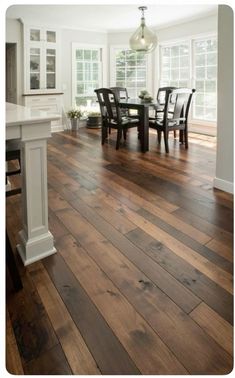 a dining room with wooden floors and white trim on the walls is pictured in this image