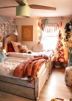 two beds in a room with christmas decorations on the walls and wooden flooring,