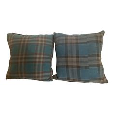 two blue plaid pillows sitting next to each other