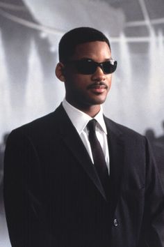 a man in a black suit and sunglasses