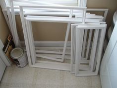 several white frames stacked on top of each other next to a window in a bathroom