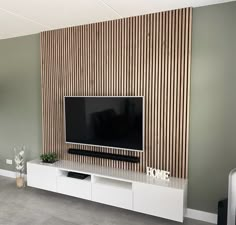 a flat screen tv sitting on top of a white entertainment center in a living room