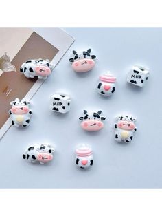 there are many small cow magnets on the table