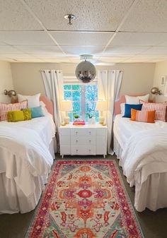 two twin beds in a bedroom with a rug on the floor