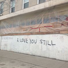 graffiti on the side of a building that says i love you still written on it