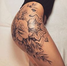 a woman's thigh with flowers and leaves on the bottom half of her leg