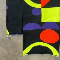 two pieces of cloth with different colored designs on them, one is black and the other is yellow