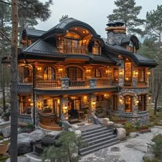 a large house with lots of windows and lights on it's sides in the woods