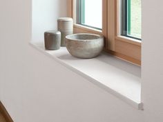 a white bowl sitting on top of a window sill next to a canister