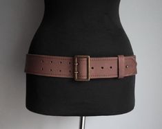 This belt is an item from the '90s. It is made of muted dark brown thick leather. It has a side ring. It fastens with rectangular brass buckle with double needle. The tip of the belt can be secured with a brass pin. Size EUR 92 / US 36 It is adjustable, 5 holes. Fits waist or low waist from 87cm / 34.2" at the first hole to 97cm / 38.2" at the last hole. Width 5.2 cm / 2.05" The belt is in good condition, it shows few wear marks, nothing major. Similar items https://www.etsy.com/shop/ForgottenSp Thick Brown Belt, Brown Belt With Brass Hardware For Everyday, Vintage Leather Belt Rectangular Shape, Rectangular Antique Brown Belt Buckles, Vintage Belts With Rectangular Antique Buckle, Vintage Belt With Antique Buckle, Brown Rectangular Belt For Everyday Use, Classic Brown Rectangular Belt Buckles, Close Pin