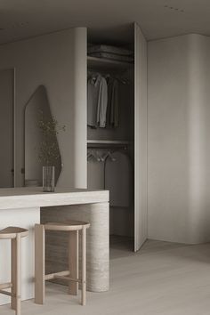 an empty room with two stools in front of the counter and closet behind it