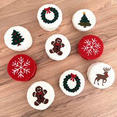 knitted christmas ornaments arranged on a wooden surface with snowflakes and reindeers