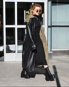 a woman walking down the street wearing black boots