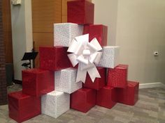 several red and white boxes stacked on top of each other with a large white bow