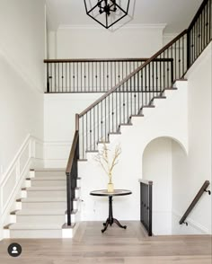 a foyer with stairs and a table in the center, along with a chandelier