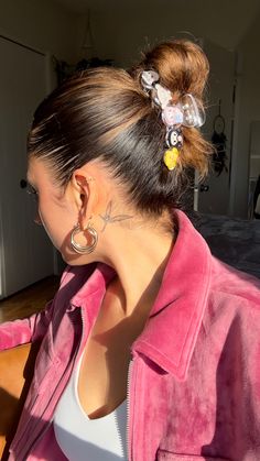 a woman with some piercings on her ear and wearing a pink jacket in the background