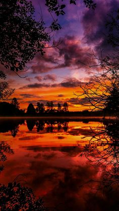 the sky is reflected in the water at sunset