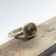 a close up of a ring on top of a piece of metal next to a ruler