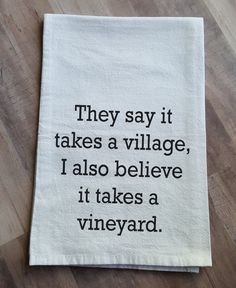 a tea towel that says they say it takes a village, i also believe it takes a vineyard